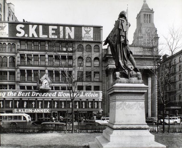 Union Square, Manhattan. Looking up at statue of Lafayette from behind and left, S. Klein's store, a bank, a hotel and the Consolidated Edison Building, beyond.