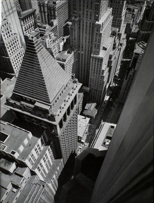 Wall Street, from roof of Irving Trust Co. Building, Manhattan. Looking down on edge of Irving Trust Bldg., pyramidal roof of building across street and Customs House, most of immage mass of buildings.