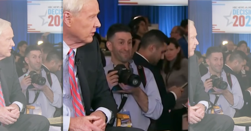 Watch a Photojournalist Crack Up in Background of a Very Serious MSNBC Interview