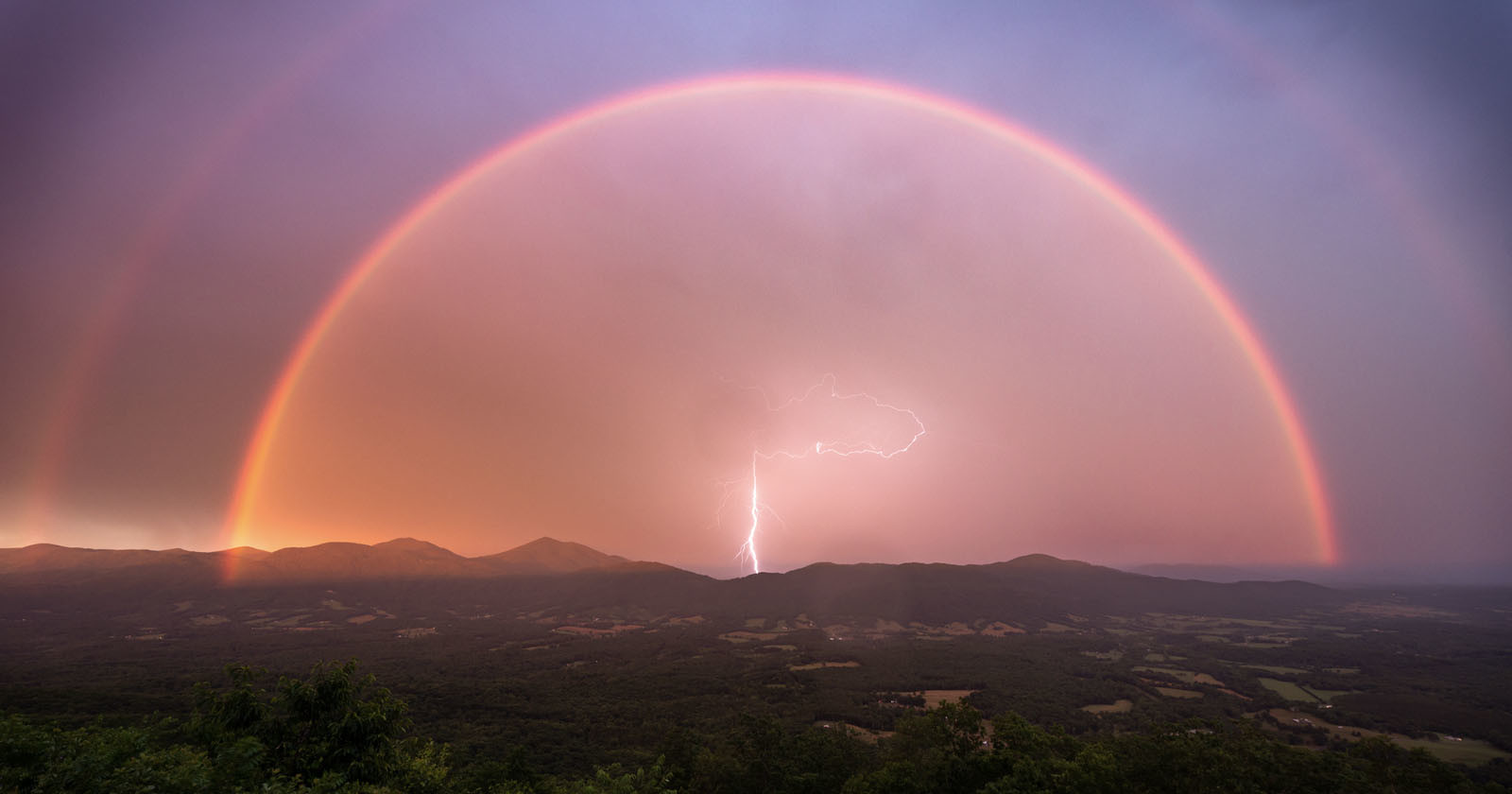 Perfect Timing: Spectacular Photo of a Lightning Bolt Under a Double Rainbow