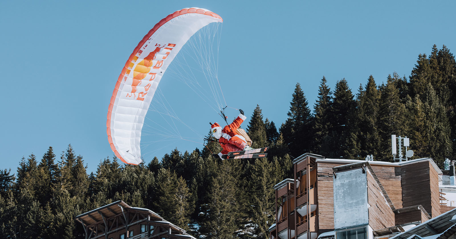 Santa Paraglides Through the Sky Throwing Cameras at People Below
