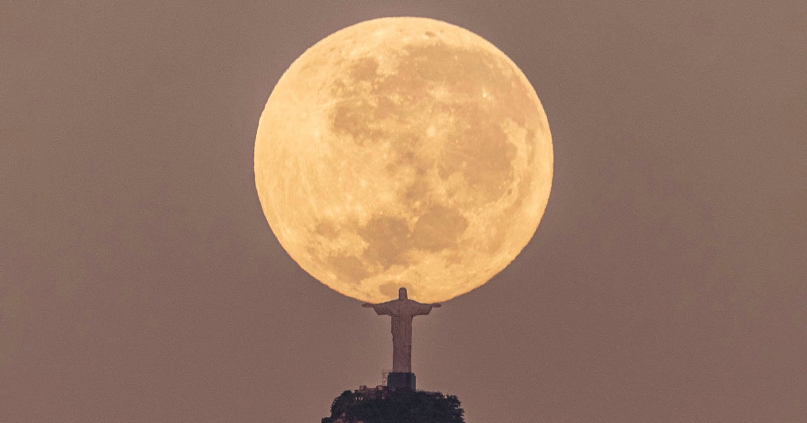  photographer captures christ redeemer holding moon 