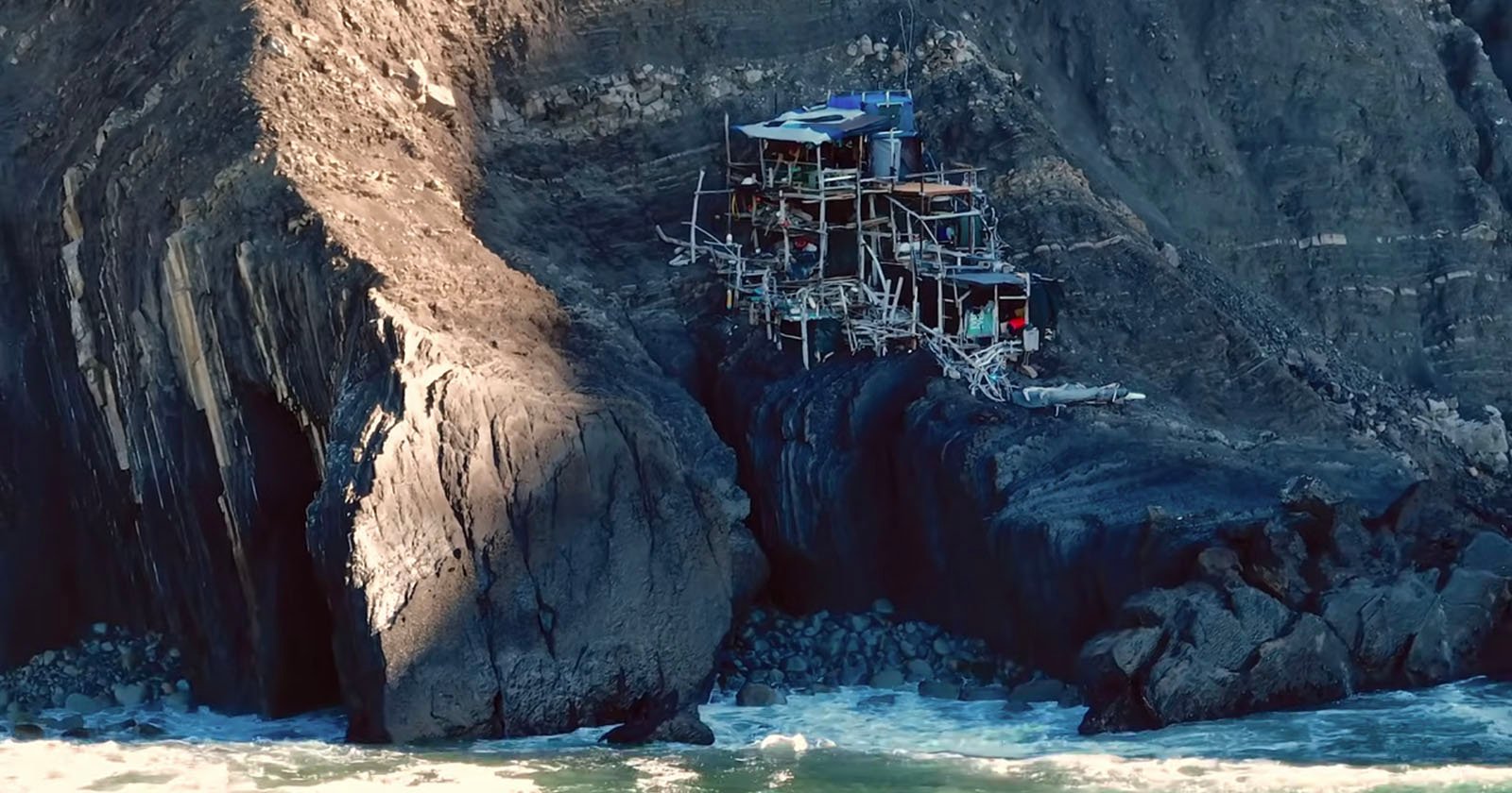  drone photographer discovers mystery driftwood shack perched cliff 