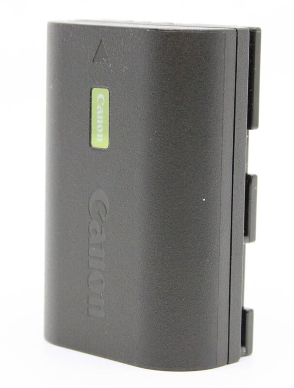 A Canon camera battery on a white background. the charger is black with visible brand logos and a green, reflective brand sticker.