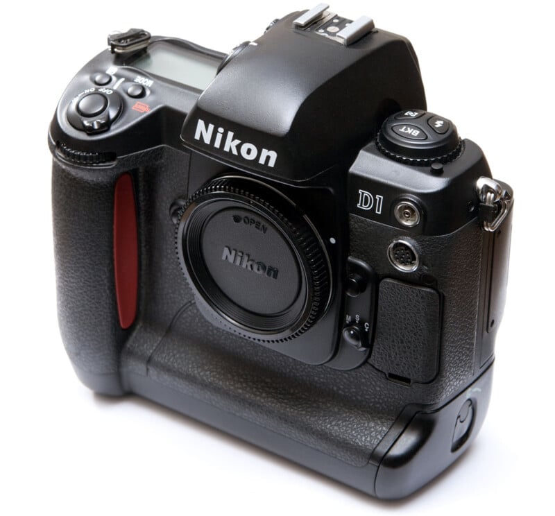 A Nikon D1 professional digital SLR camera body without a lens, showing various buttons, dials, and the grip, photographed against a white background.