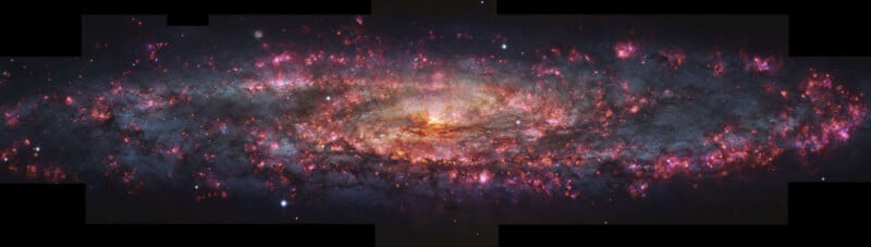 A vibrant, colorful spiral galaxy filled with glowing pink, orange, and blue clouds of gas and dust, with bright stars scattered across a dark space background.