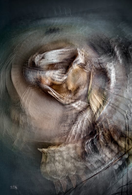 Abstract digital artwork featuring swirling, layered textures in muted earth tones. Shapes resemble petals, feathers, and organic forms, creating a sense of motion and depth within a circular composition.