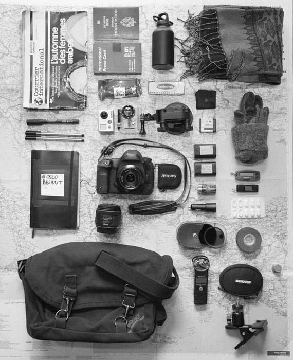 Courrier International, press card, passport, water, scarf, chocolate, plaster, microfiber cloth, marker and pens, go pro hero 2 + suction mount and spare battery, gloves, travel diary / notebook, Canon 5Dmk3 + memory cards + 2 batteries + 40mm lens + 28mm lens, AA batteries, bank thing, USB key, painkillers, car charger for cellphone, filters in a box, gaffer tape, sound recording device, earphones, coins, ballhead clamp for camera, map of Eastern Europe and Turkey. Wallet and cellphone are in jeans pockets.