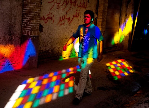  A young worker walks through the light of a stained glass window in the Tehran Bazaar. Under Khomeini Iranians were actively encouraged to produce large families. By 2009 nearly 70% of all Iranians were under 30, but the country is the least religious in the Middle East. Instead of the "armies for Islam" Khomeini had called for, the youthful population is now seen as the biggest threat to the deeply unpopular regime.