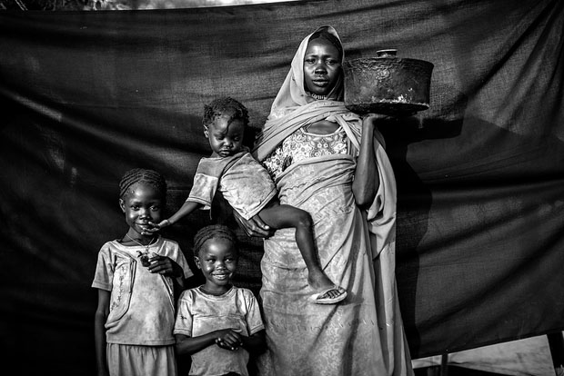 The most important thing Magboola was able to bring with her is the cooking pot she holds in this photograph. It was small enough she could travel with it, yet big enough to cook sorghum for herself and her three daughters during their journey.