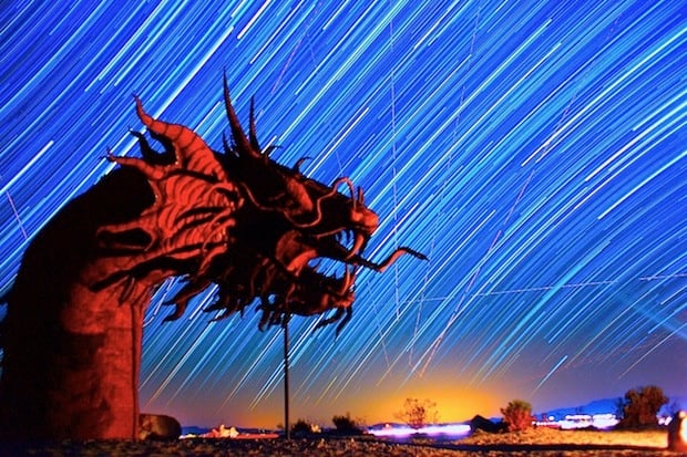 Galactic star trails pass giant dragon statue. Sculptures by Ricardo A Breceda. Photo by Gavin Heffernan.