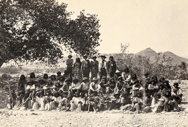 Native American (Paiute) men, women and children posing under a tree near Cottonwood Springs (Washoe County), Nevada. Taken in 1875.