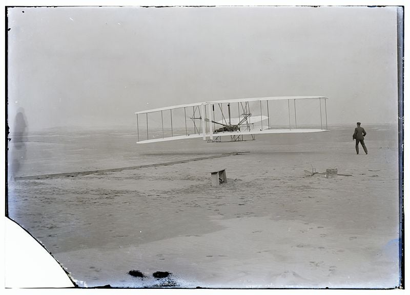 Photo (by John T. Daniels) of the first powered, controlled, sustained flight, Dec. 17, 1903. The author has run along the same spot just as Wilbur Wright is doing at right. Source: U.S. Library of Congress (public domain).