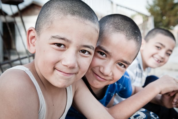 Three boys smile on the main street of Zahmet, Turkmenistan.