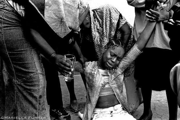 Friends and relative comfort Lebohang Mokoena, 3yr old S'bongile's aunt and the person who was looking after her when she disappered.  Kliptown Community Hall. Soweto, Johannesburg, December 2003.