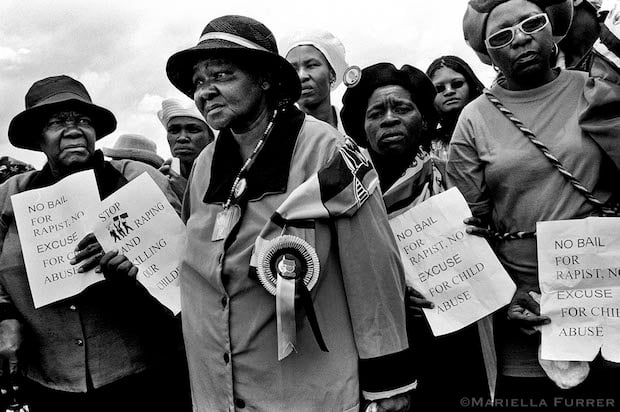 Members of the ANC Women's League hold out flyers that they were distributing at the funeral of 3yr old S'bongile Mokoena who was raped and murdered on November 8, 2003. Soweto, December 2003.