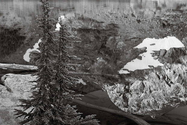 Trees frame granite cliffs reflected in Cabin Lake.