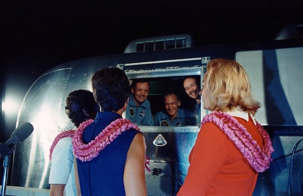 Apollo 11 astronauts, still in quarantine van, are greeted by wives upon arrival at Ellington Air Force Base.