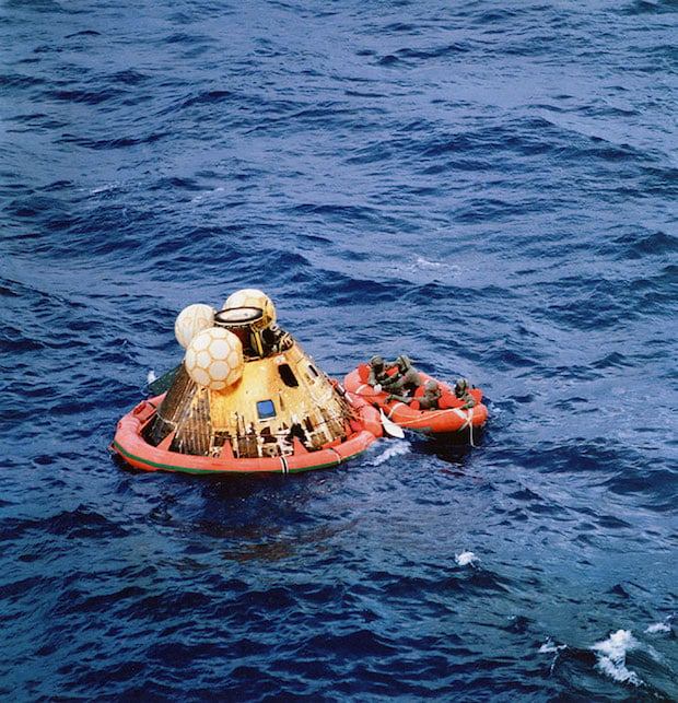 Apollo 11 crewmen await pickup by helicopter following splashdown.