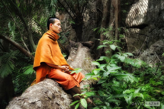 A monk in a meditative pose in Kanchanburi province, Thailand