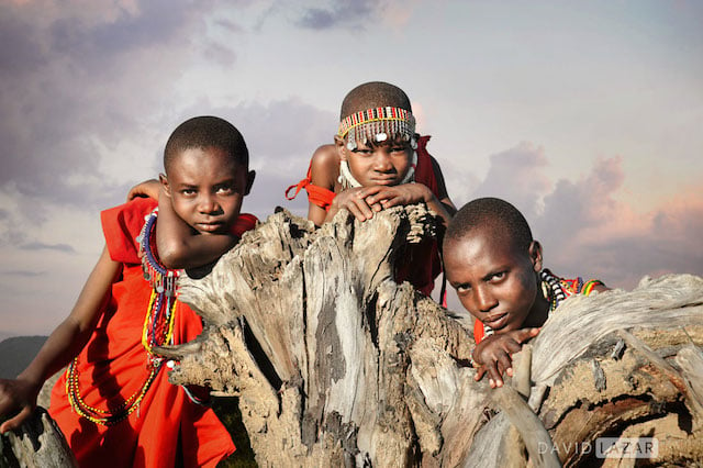 Masai children in Kenya interacting with their own bodies and an uprooted old tree