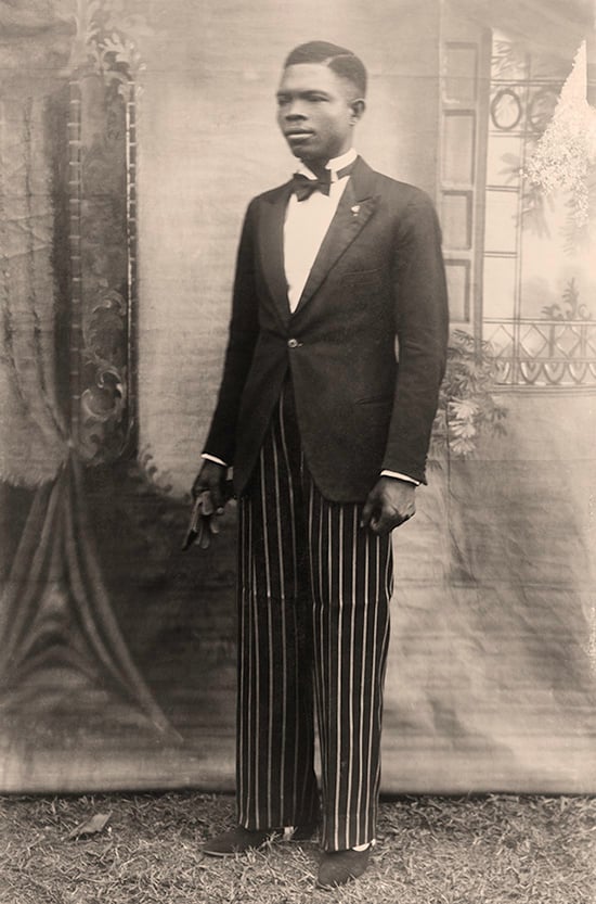  Solomon Osagie Alonge, “Self-portrait with painted studio backdrop” (1942),  Silver gelatin print, with sepia tone (Chief S. O. Alonge Collection, Eliot Elisofon Photographic Archives)