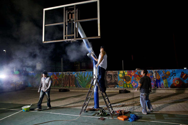 Villagers paint the basketball stadium in Guelatao de Juarez.