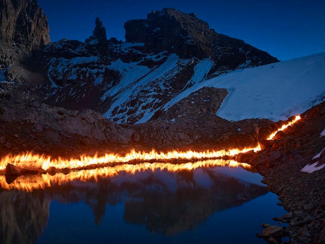 The flame line shows the Lewis Glacier's location in 1947 along the edge of the Curling Pond. In 1947 the level of the pond was 15m higher and the back of the pond was a tall cliff of ice. The glacier has since receded about 120m.