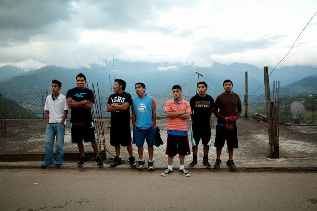 Men await the inauguratory parade of the basketball tournament in San Cristobal Lachiroag.