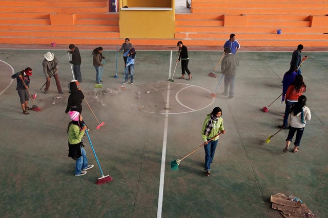 Villagers sweep the basketball court the morning before the tournament as part of a tequio, or obligatory task for all villagers, in Tlahuitotepec.