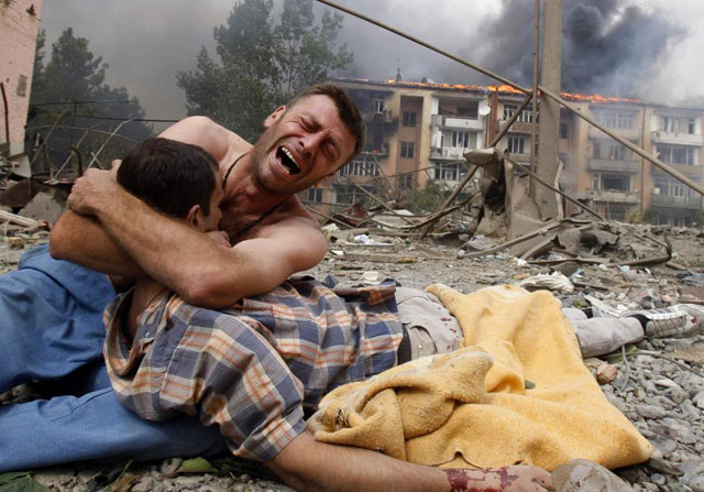 A Georgian man cries as he holds the body of his relative after a bombardment in Gori, Georgia, August 9, 2008. Gleb Garanich.