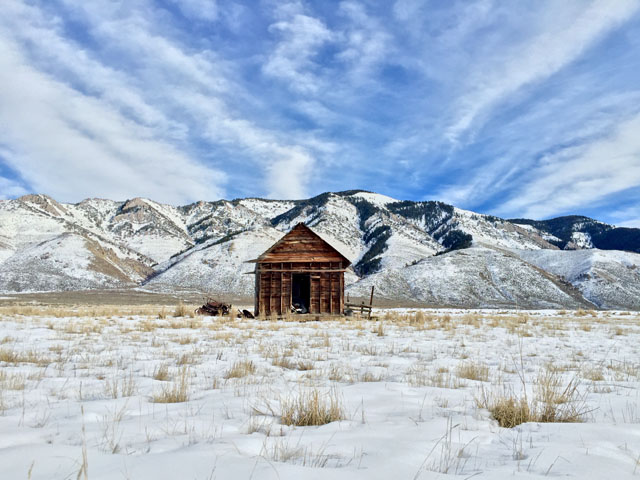 Shot by Cole R. in Star Valley Ranch, WY. Establishing a central focal point can have dramatic impact. Here, wispy clouds lead the eye to the hut and create a stronger sense of focus.