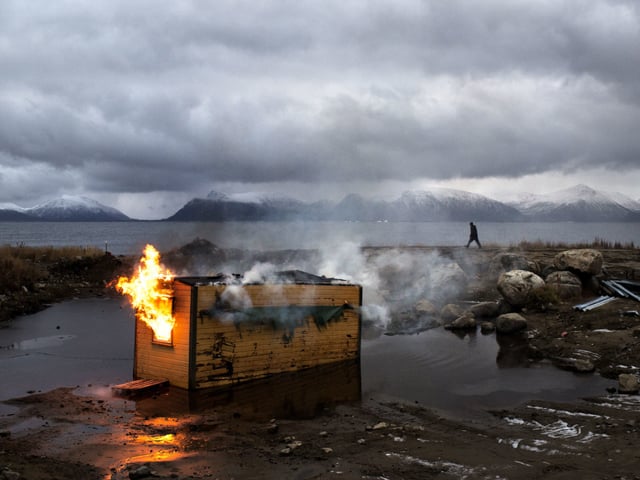 NORWAY, Klo, Vesteraalen. 2012.  As part of clearing an area to build an amateur racetrack for cars, local enthusiasts put fire to an old barracks.