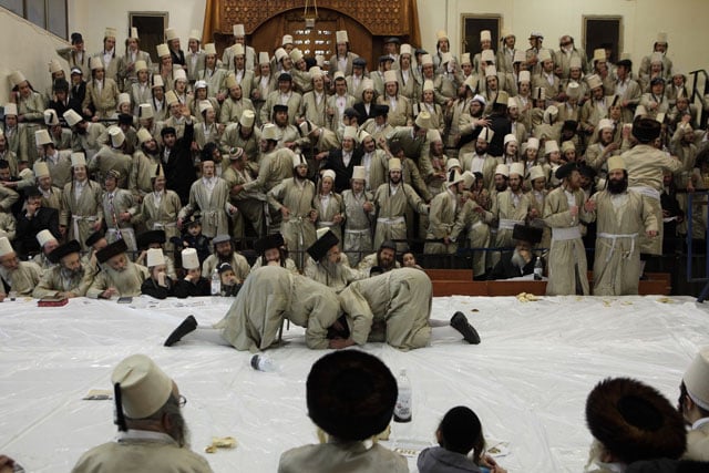 Hasidic Jews dancing at a table called 'Tish' during the Jewish holiday Purim.