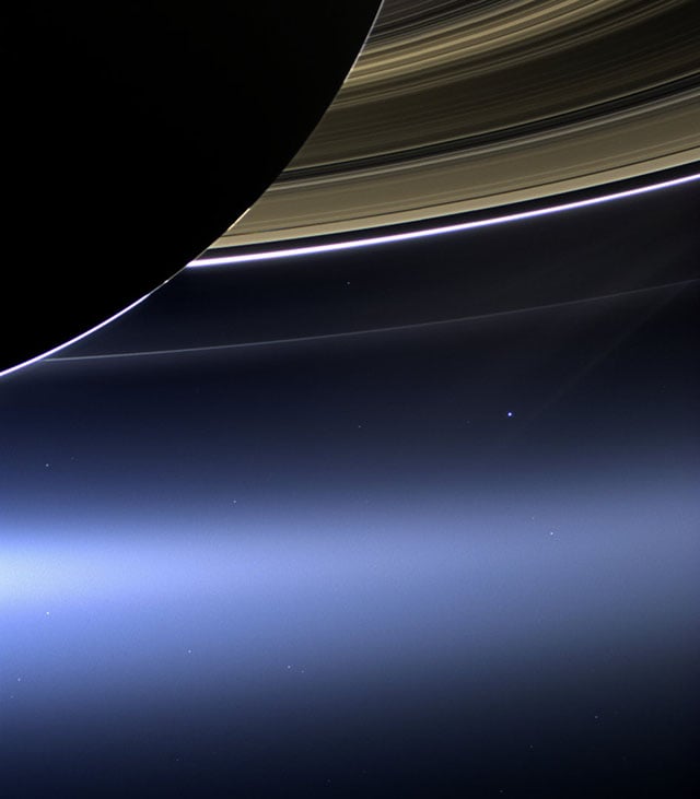 Earth seen as a pale blue dot under Saturn's rings.