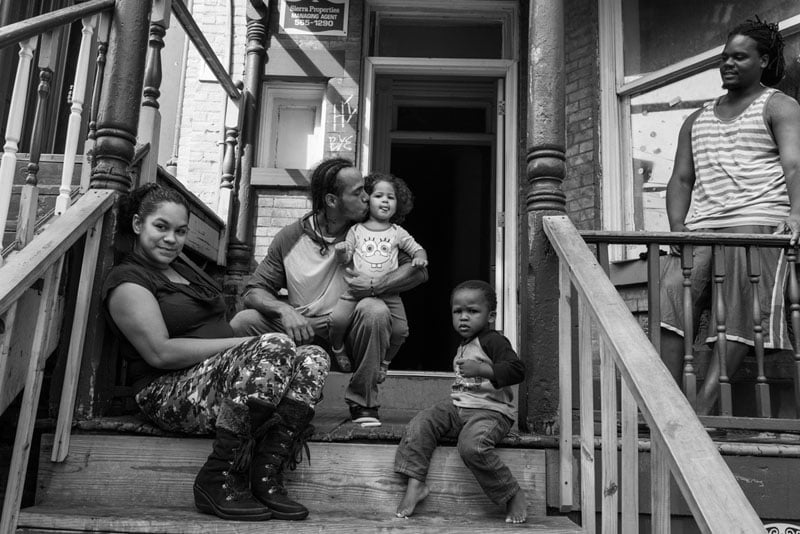 On a sunny Saturday on Dubois Street, a Newburgh family enjoying their front porch. Sarah Bones/Photographers for Hope