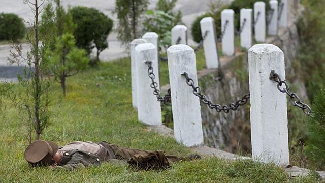 A North Korean soldier sleeping in a field.
