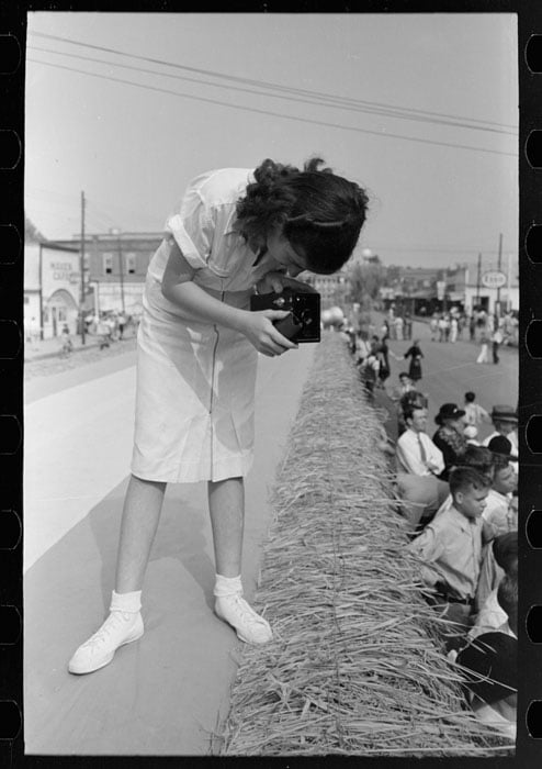 Girl taking picture of crowd, National Rice Festival, Crowley, Louisiana. Photo by Russell Lee.