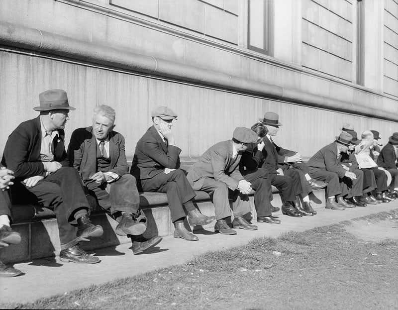 Unemployed men sitting on the sunny side of the San Francisco Public Library. California. February 1937.