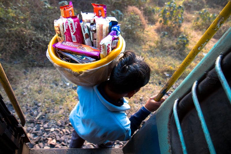 A snacks vendor prepares for a rolling disembarkation near Asansol, West Bengal. He made it look easy, but stepping off a moving train in flip-flops onto coarse gravel while balancing a tub of cookies on your shoulder is an art, without a doubt.
