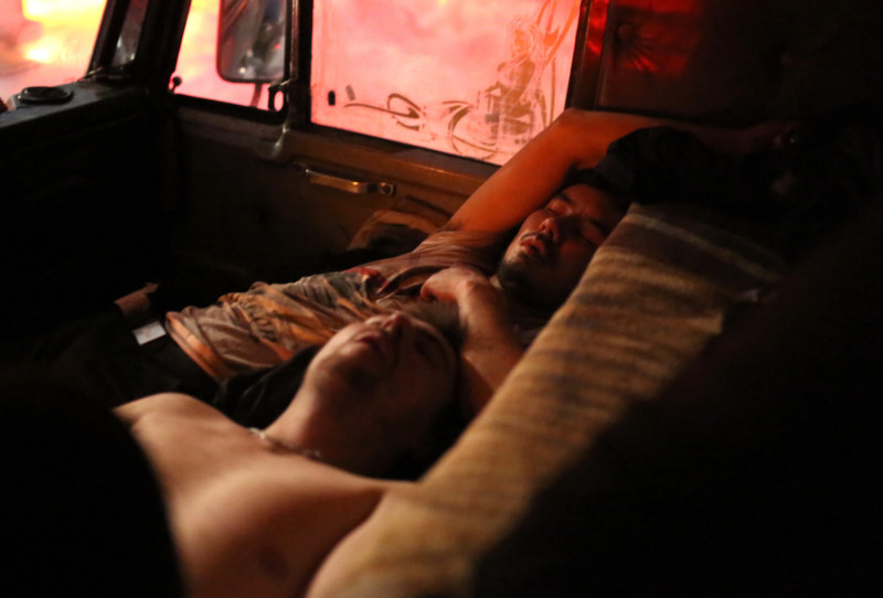 Ruslan and Gerrick asleep in the cab. Ruslan's truck is equipped with a powerful heater. With the temperatures at times hovering around zero it's uncomfortably hot through the night and windows can only be opened a crack.