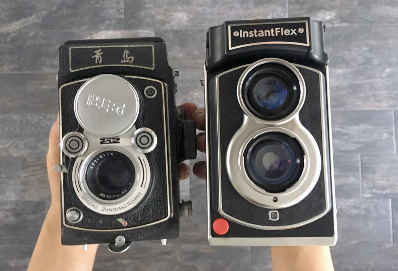 The InstantFlex TL70 2.0 next to an old twin-lens reflex camera.