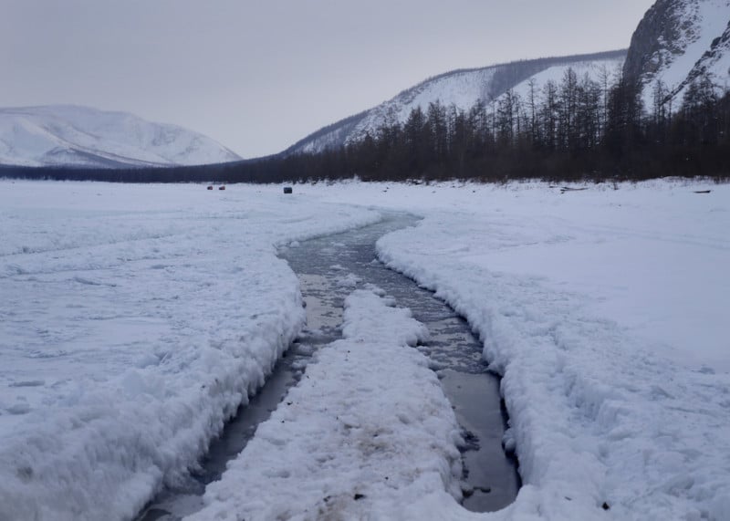 As the spring melt begins, water levels on the river start to rise, pushing through cracks in the ice. This can freeze overnight, forming a brittle layer above a bedrock of ice below. Ruslan referred to this kind of driving as "swimming".