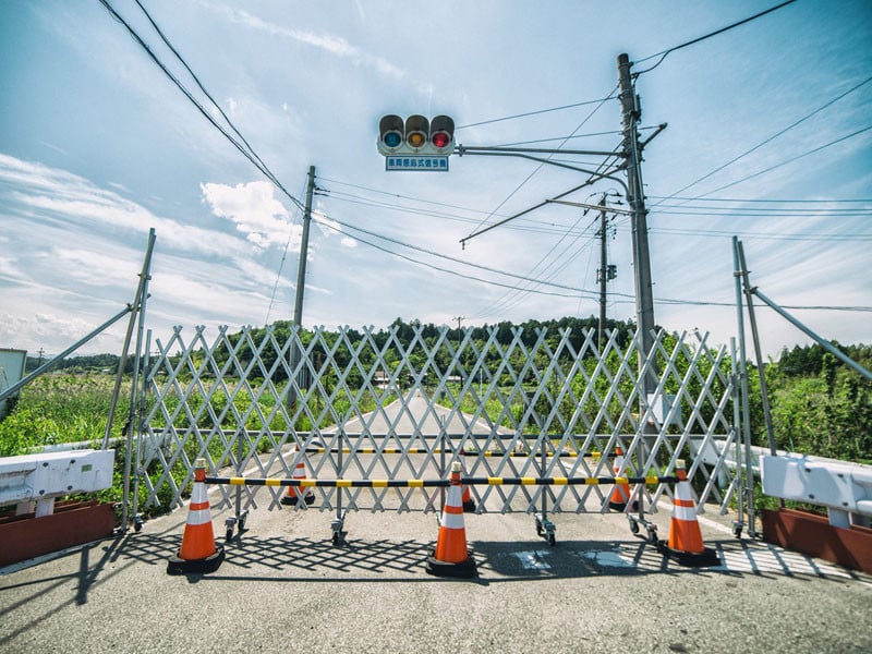 A barricade blocks the road into the town of Okuma.