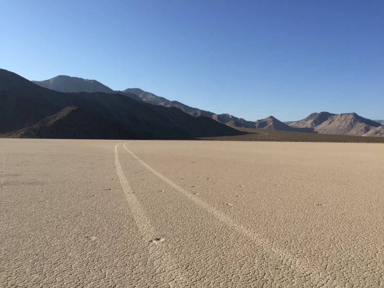 From the rocks area, car tracks tail off into the distance