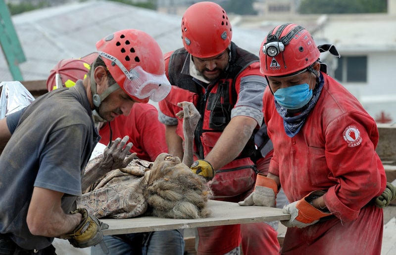 Ena Zizi is pulled alive on January 19, 2010, from the rubble of Haiti's devastating earthquake, one week after the city was reduced to ruins in a matter of seconds. The 70-year old woman was rescued from the collapsed home of the parish priest at Port-au-Prince's Roman Cathedral Cathedral of Our Lady of the Assumption by members of a Mexican search and rescue team, several of whom were in tears as they pulled the woman free from tons of rubble. She suffered from dehydration, a dislocated hip and a fractured leg, and was taken by helicopter to the U.S.S. Bataan for treatment. She told an interviewer she stayed alive by talking with God. Under "informed consent" rules that require prior written approval, the photographer would have had to stop the rescue, explain the intricacies of usage and consent in two different languages, get the appropriate signatures, then allow the rescue to continue. Photo by Paul Jeffrey.