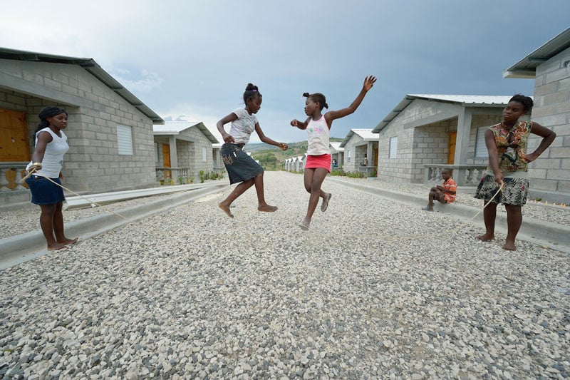 Children jump rope in 2013 in a model resettlement village constructed by the Lutheran World Federation in Gressier, Haiti. The settlement houses 150 families who were left homeless by the 2010 earthquake, and represents an intentional effort to "build back better," creating a sustainable and democratic community. Under "informed consent" rules that require prior approval, the photographer would have had to stop the girls from playing, have them identify their parents, explain the intricacies of "informed consent" and usage, get their signature, and then return to the street and photograph the girls at play. That's a process that's allegedly designed to assure that the girls are not depicted in an undignified manner. Photo by Paul Jeffrey.