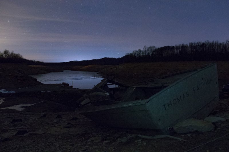 A flashlight covered with a plastic shopping bag lit the corner of the boat to provide more subdued lightning that would blend with the highly reflective surrounding land. The light was on during the entire 15 second exposure at ISO 6400 and f/3.5.