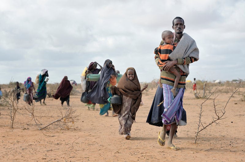 Newly arrived refugees carry their belongings through the Dadaab camp in northeastern Kenya in 2011. Long the world's world's largest refugee settlement, Dadaab swelled with tens of thousands of new arrivals fleeing drought in Somalia. Under "informed consent" rules that require prior approval, the photographer would have had to stop the tired family, explain the intricacies of usage and consent, then get their signatures on the paperwork before allowing them to continue their trek across the hot desert. Photo by Paul Jeffrey.