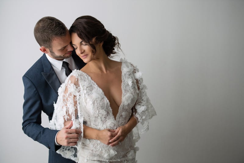 Posing for the camera. Young wedding couple. Romantic Married Couple. The  bride and groom stand leaning